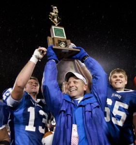 Cincinnati St. Xavier coach Steve Specht holds up the trophy and celebrates with Nick Schneider (13) and Max Baumann (65) after St. Xavier beat Mentor 27-0 in the Division I state final football game Saturday, Dec. 1, 2007, in Canton, Ohio. (AP Photo/Tony Dejak)